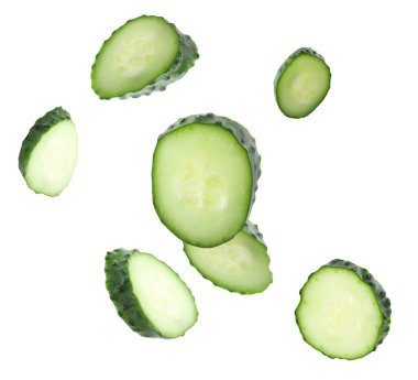 Beyaz arka plana düşen taze salatalık parçaları.