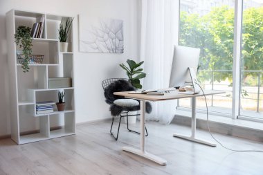 Ev çalışma alanı. Modern bilgisayar, ev bitkisi ve kırtasiye malzemesi ahşap masa içinde.