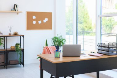 Ev çalışma alanı. Modern laptop ve kırtasiye malzemeleri ahşap masa içinde.