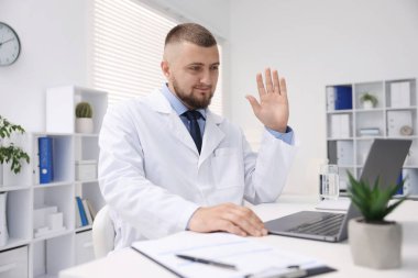 Klinikte bilgisayarla online danışmanlık yapan bir doktor