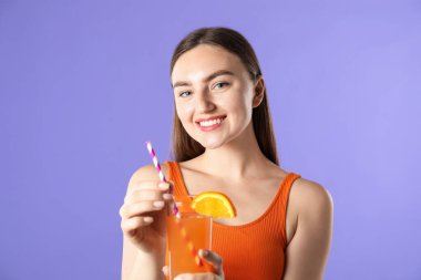 Menekşe arka planında canlandırıcı içecek ve saman olan kadın.