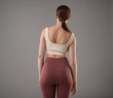 Gri arka planda kötü duruşu olan kadın, arka plan