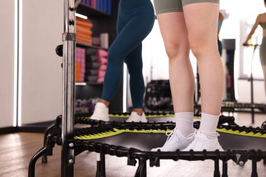 Spor salonundaki tramplenlerde antrenman yapan kadınlar, yakın çekim.