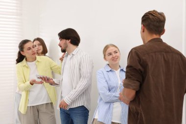 Bir grup insan içeride kuyrukta bekliyor.