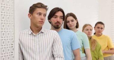 Bir grup insan içeride kuyrukta bekliyor.