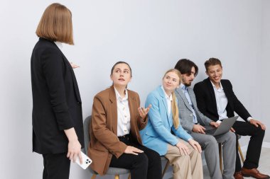 İnsanlar içeride sandalyede kuyrukta bekliyorlar.