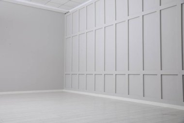 Beyaz ahşap zemin ve duvarları olan boş bir oda.