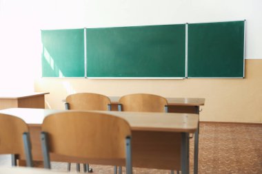 Sınıfta sandalyeli ve yeşil karatahtalı masalar