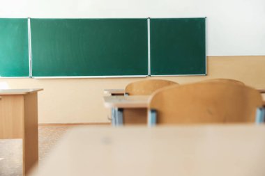 Sınıfta sandalyeli ve yeşil karatahtalı masalar