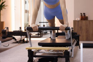 Pilates stüdyosunda yenilikçi kadın egzersizi, yakın çekim.