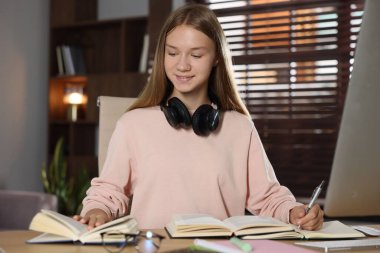 Genç kız çevrimiçi olarak kapalı bir masada çalışıyor.