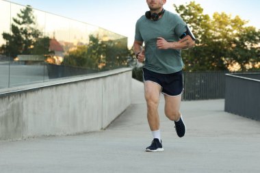Spor giyimli atletik genç adam dışarı koşuyor, yakın plan. Metin için boşluk