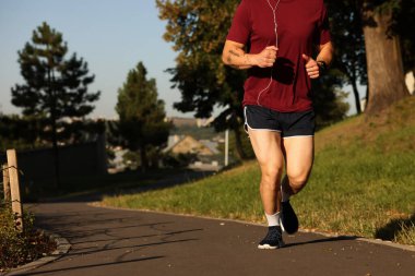 Spor giyimli atletik genç adam dışarı koşuyor, yakın plan. Metin için boşluk