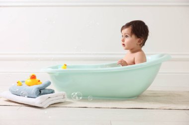 Evde küvette banyo yapan şirin bir bebek.