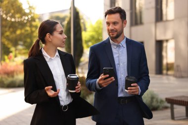 Paket kahve. Açık havada kağıt bardak içen iş adamları.