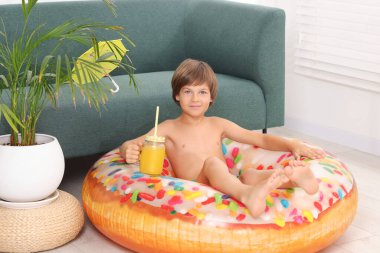 Denizde tatilin hayalini kuruyorum. Duvarcı kavanozunda taze meyve suyu ve şişme yüzükle küçük bir çocuk.