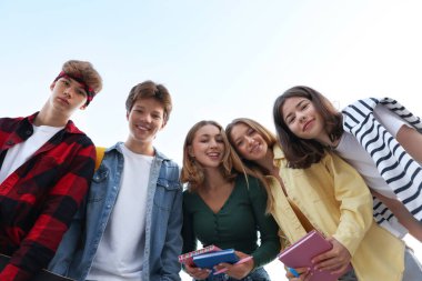 Mavi gökyüzü altındaki gençlerin portresi, düşük açı