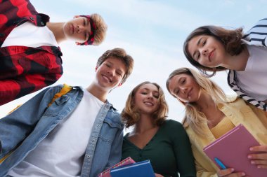 Mavi gökyüzü altındaki gençlerin portresi, düşük açı