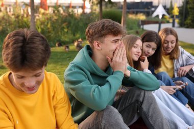 Bir grup genç parkta birlikte vakit geçiriyorlar.