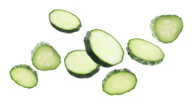 Beyaz arka plana düşen taze salatalık parçaları.