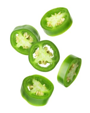 Jalapeno biber parçaları beyaz arkaplana düşüyor