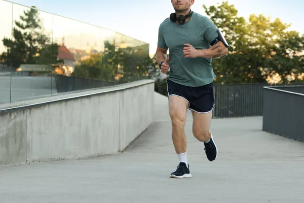 Spor giyimli atletik genç adam dışarı koşuyor, yakın plan. Metin için boşluk