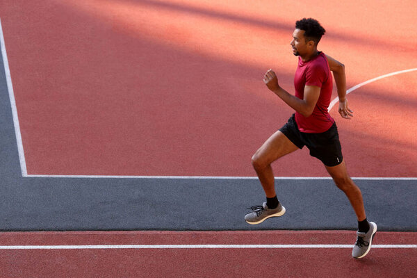 Красавчик в спортивной одежде бегает по стадиону. Пространство для текста