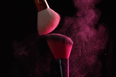 Siyah arka planda pembe göz farlı makyaj fırçaları, yakın plan