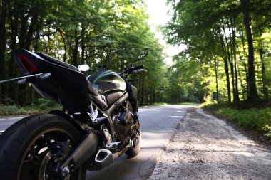 Modern siyah motosiklet açık yolda park edilmiş. Metin için boşluk