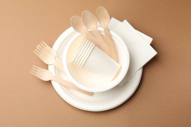 Kahverengi arkaplanda tek kullanımlık tablo takımı, üst görünüm