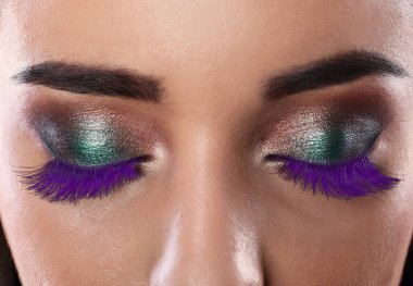 Güzel makyajlı ve mor kirpikli genç bayan, yakın plan.