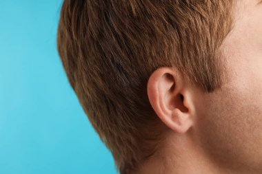 Ses geliyor. Açık mavi arka plandaki adam, yakın plan. Metin için boşluk