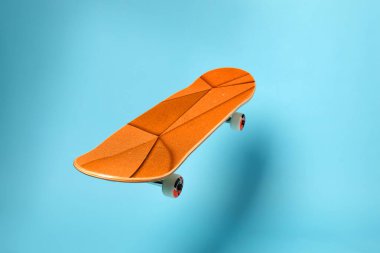 Açık mavi arka planda turuncu desenli kaykay