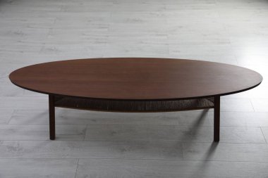 Kapalı alanda yerde boş ahşap masa. Mobilyalar şık.