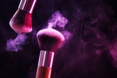 Renkli göz gölgeli makyaj fırçaları siyah arka planda neon ışıkları, yakın plan. Metin için boşluk