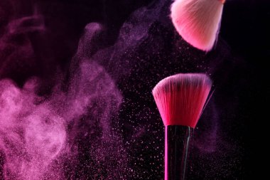 Siyah arka planda pembe göz farlı makyaj fırçaları, yakın plan. Metin için boşluk