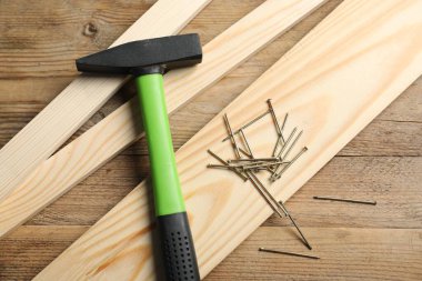 Çekiç, metal çiviler ve tahtalar tahta masada, düz yatıyordu.