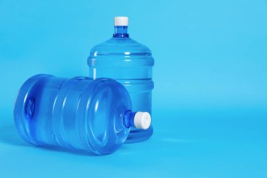 Açık mavi zemin üzerinde su olan soğutucu şişeler. Metin için boşluk