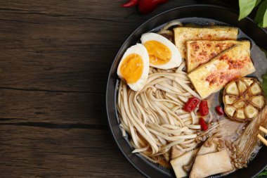 Ahşap masadaki mantarlı, Enoki ve Kral istiridye (eryngii) mantarlı lezzetli ramen. Metin için boşluk
