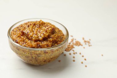 Beyaz mermer masanın üzerinde tam tahıllı hardal, yakın plan. Metin için boşluk