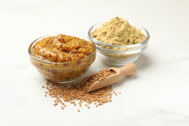 Beyaz mermer masa üzerinde farklı hardal türleri, yakın plan.