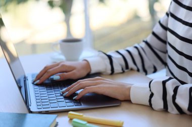 Masada dizüstü bilgisayarla çalışan kadın arka planı bulanık, yakın plan