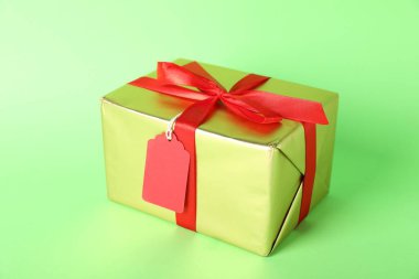 Yeşil arkaplanda boş etiketli hediye kutusu, kapat