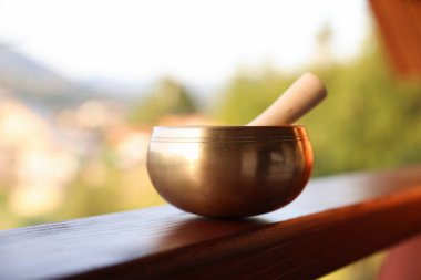 Tibet şarkı kasesi. Tırabzanda tokmak var. Açık havada.