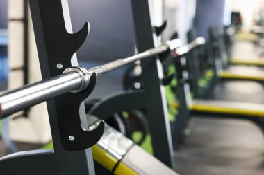 Spor salonunda halterli ağırlık bankı, yakın plan.