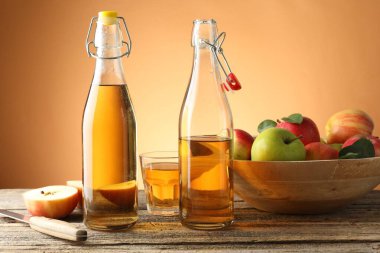 Şişe, cam, elma ve bıçak dolu nefis elma şarabı portakal eğimli arka planda.