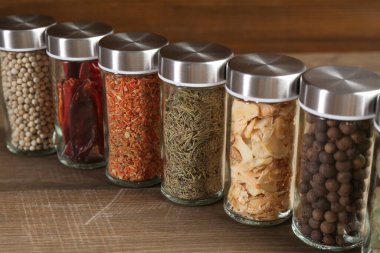 Farklı baharatlar ve kavanozlar ahşap masada, yakın plan