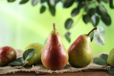 Tahta masada yeşil yapraklı taze armutlar, yakın plan.