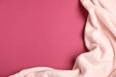 Pembe arka planda bej havlu, üst manzara. Metin için boşluk