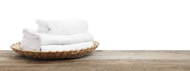 Ahşap masanın üzerinde beyaz arka plana karşı katlanmış havlu yığını, yakın plan. Metin için boşluk